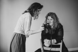 Boudoir Fotografin Ann-Katrin zeigt ihrer Kundin ein erstes Bild von ihrem Selbstliebe Shooting, diese ist von ihrer Sinnlichkeit begeistert